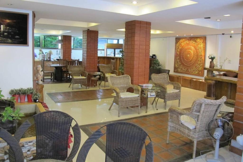 a lobby with chairs and tables in a building at Jomtien Hostel 3 in Jomtien Beach