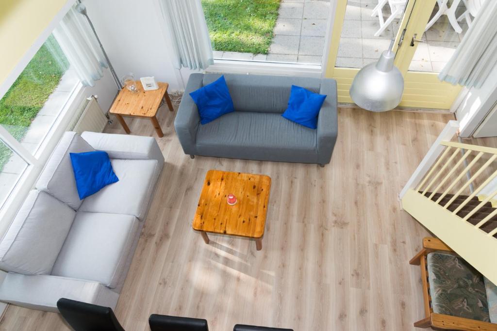 an overhead view of a living room with a couch and blue pillows at Hello Zeeland - Vakantiehuis Duinroos 167 in Breskens