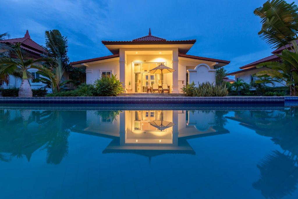 a villa with a swimming pool at night at Villa Bougainvillea in Hua Hin
