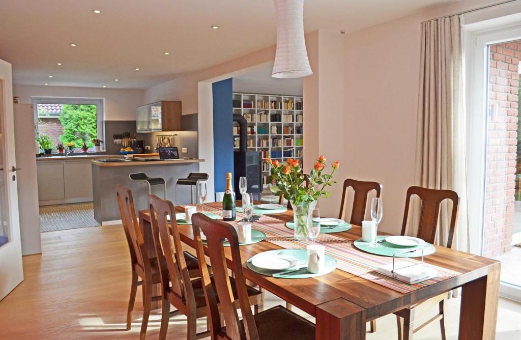 a dining room and kitchen with a wooden table and chairs at Schleiglanz in Ulsnis