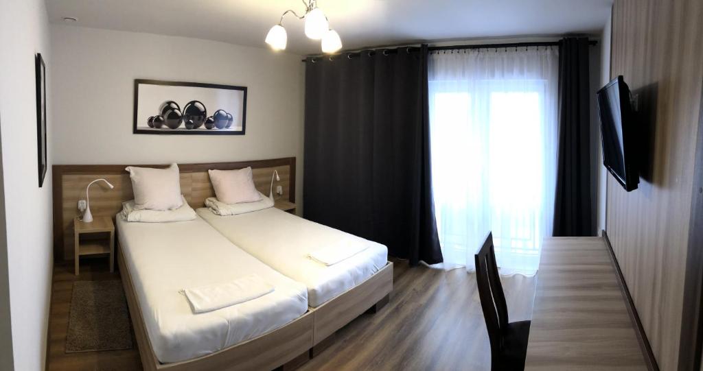 una camera d'albergo con letto e finestra di Hotel Restauracja Prezydencka a Legionowo