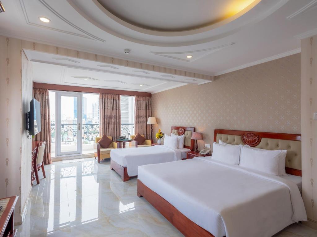a hotel room with two beds and a large window at Bon Ami Hotel - Thiên Xuân Hotel in Ho Chi Minh City
