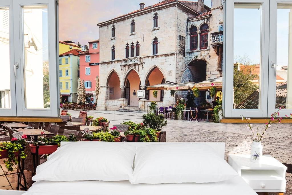 a bed outside a window with a view of a street at Villa Galla in Split