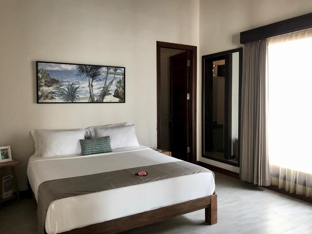 a bedroom with a large bed and a window at Villa Bella Vista in Nusa Lembongan