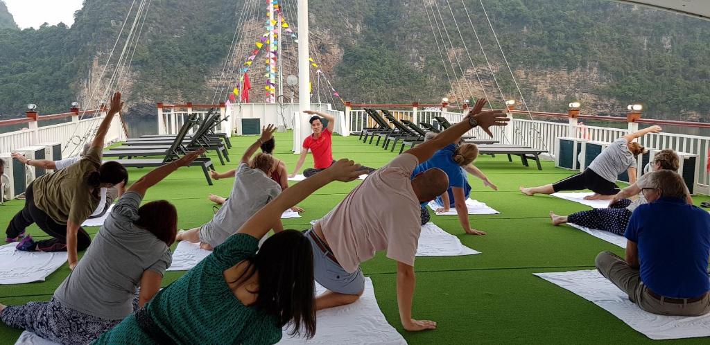 a group of people doing yoga on a cruise ship at Calypso Cruises in Ha Long