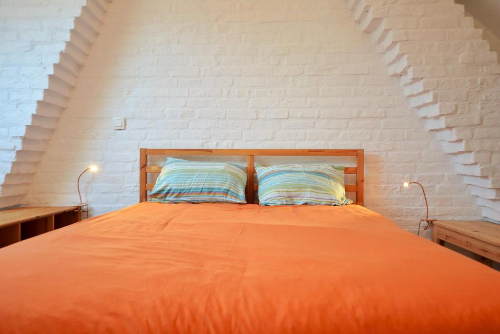 エークロにあるSylvie's House Sterrestraatのベッドルーム1室(オレンジ色のベッド1台、枕2つ付)