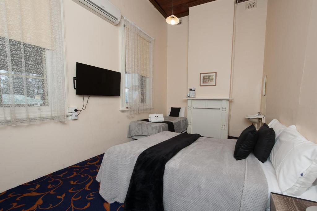 a bedroom with a bed and a flat screen tv at Riverina hotel in Holbrook