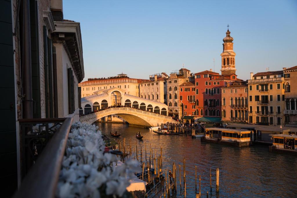 Riva del Vin BOUTIQUE HOTEL في البندقية: جسر فوق نهر في مدينة بها مباني