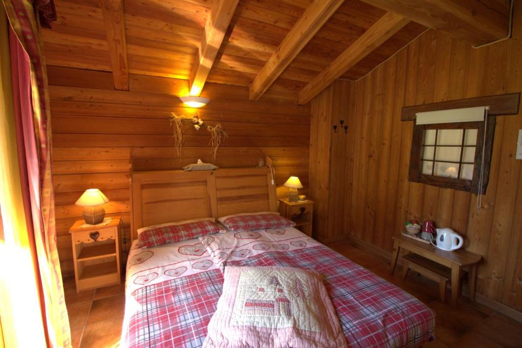 una camera con un letto in una baita di tronchi di La Grandze de François a Ollomont