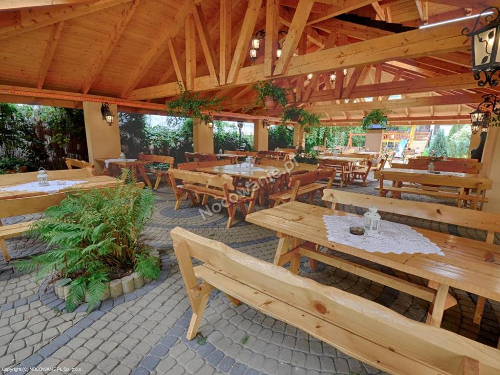 odkrytą restaurację z drewnianymi stołami i ławkami w obiekcie Apartamenty Bahus - Centrum w Ustroniu