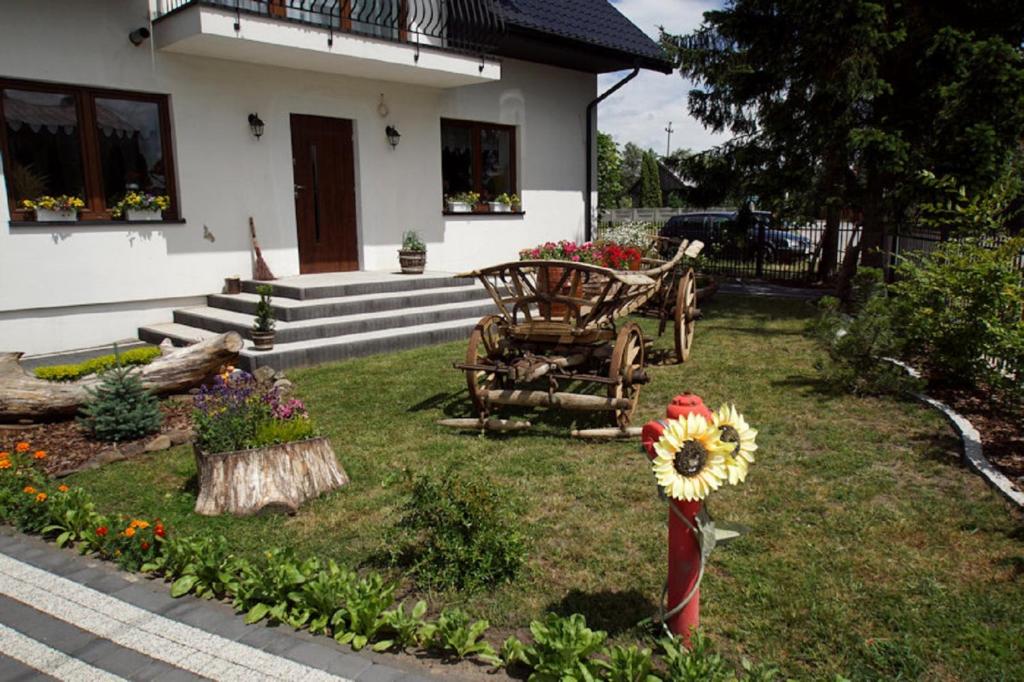 a house with a yard with flowers in the grass at Agroturystyka "u kuremzy" in Bieliny