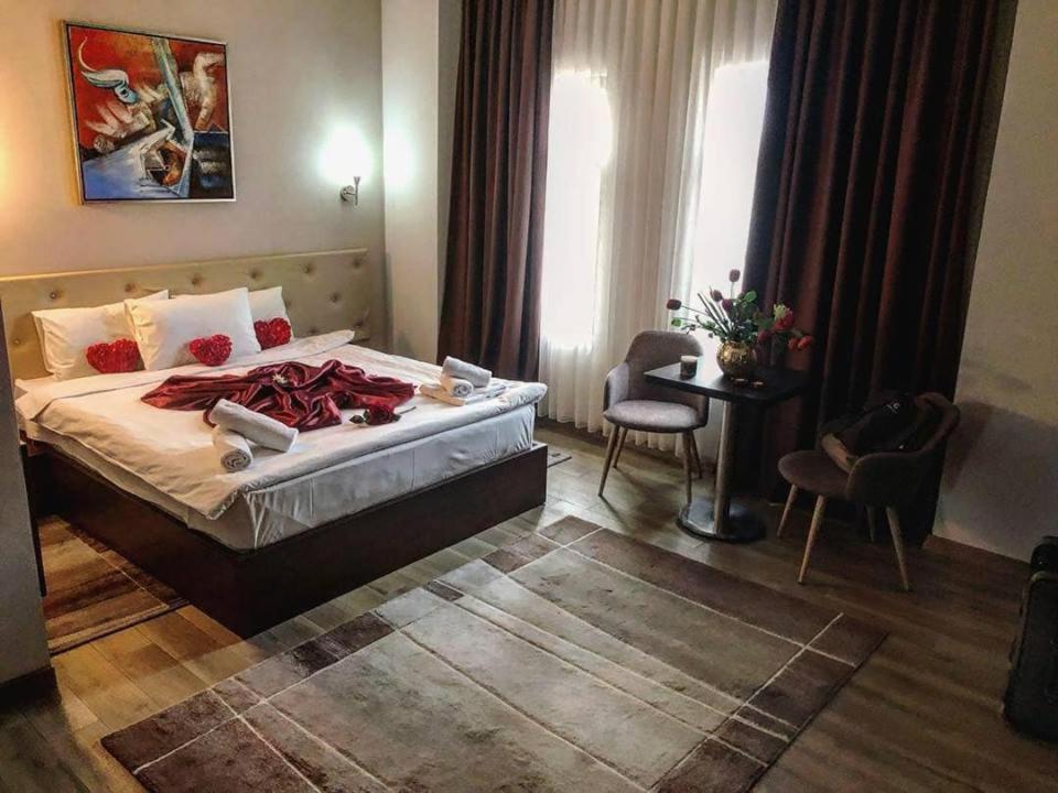 een hotelkamer met een bed en een tafel en stoelen bij AEN Hotel-Old City in Skopje