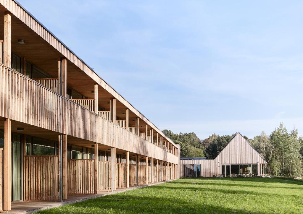 an exterior view of a building with a grass field at Waldstrand-Hotel Großschönau in Großschönau