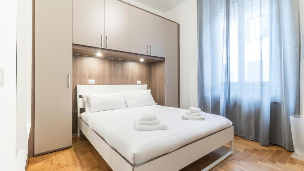 1 dormitorio con 1 cama blanca grande y espejo en Italianway-San Maurilio 20 studio en Milán