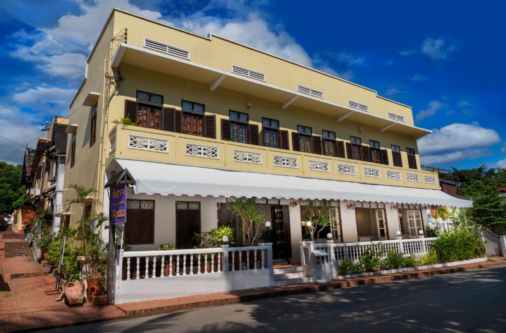 żółty budynek z balkonami na ulicy w obiekcie The Apsara w mieście Luang Prabang