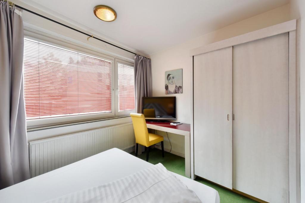 a bedroom with a bed and a desk with a computer at Am Neutor Hotel Salzburg Zentrum in Salzburg