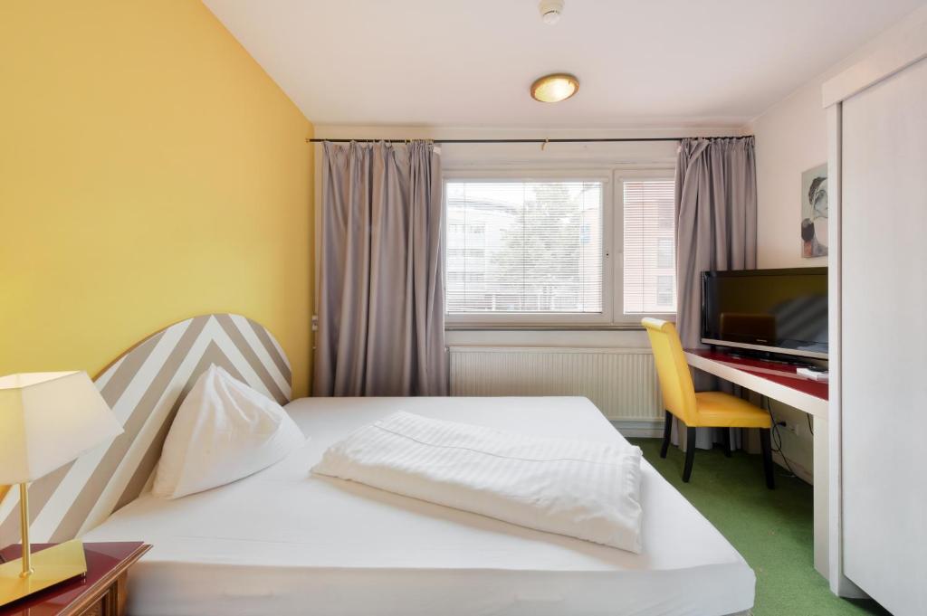 a bedroom with a bed and a desk with a computer at Am Neutor Hotel Salzburg Zentrum in Salzburg