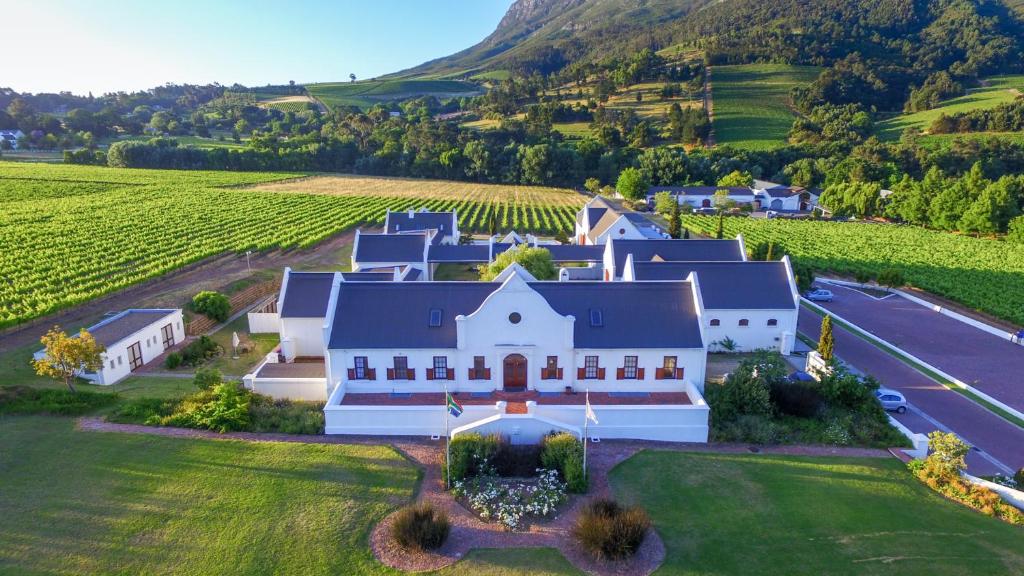 an aerial view of a large white house in a vineyard at Zorgvliet Wines Country Lodge in Stellenbosch
