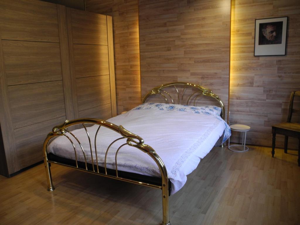 uma cama num quarto com uma parede de madeira em Appart sympa à Pepinster em Pepinster