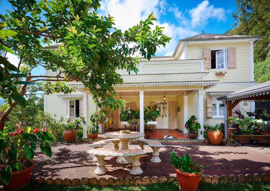 a white house with a fountain in front of it at Relais Des Gouverneurs in Salazie