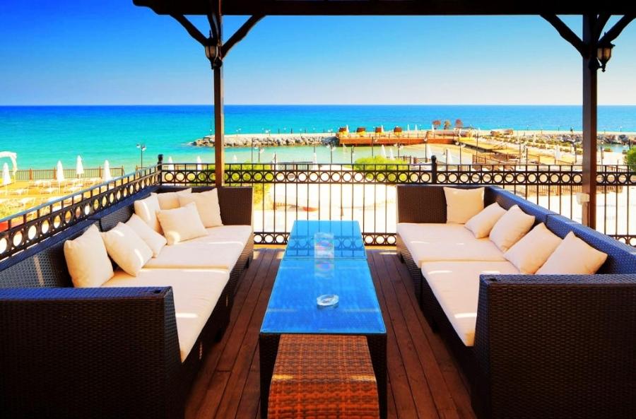 een balkon met een bank en uitzicht op de oceaan bij ADA Hotel Superb Beachfront Location ! in Kyrenia