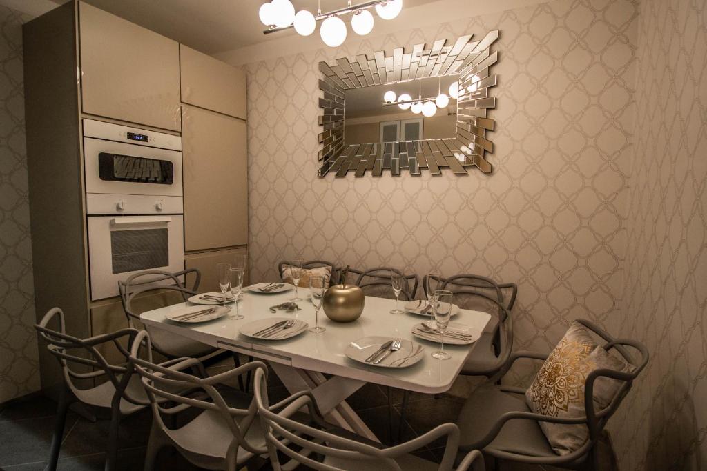布拉格的住宿－Pastel Art Deco 3BDR Ruterra Apt，一间带桌椅和镜子的用餐室