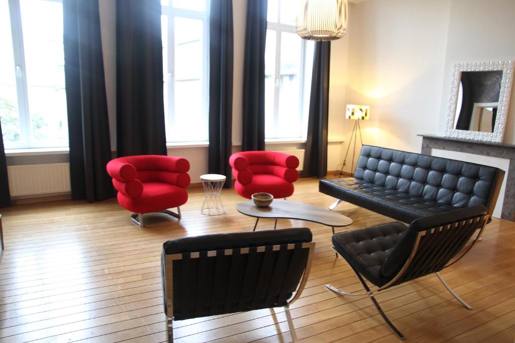 een woonkamer met een bank en rode stoelen bij Hoogpoort Residence George in Gent