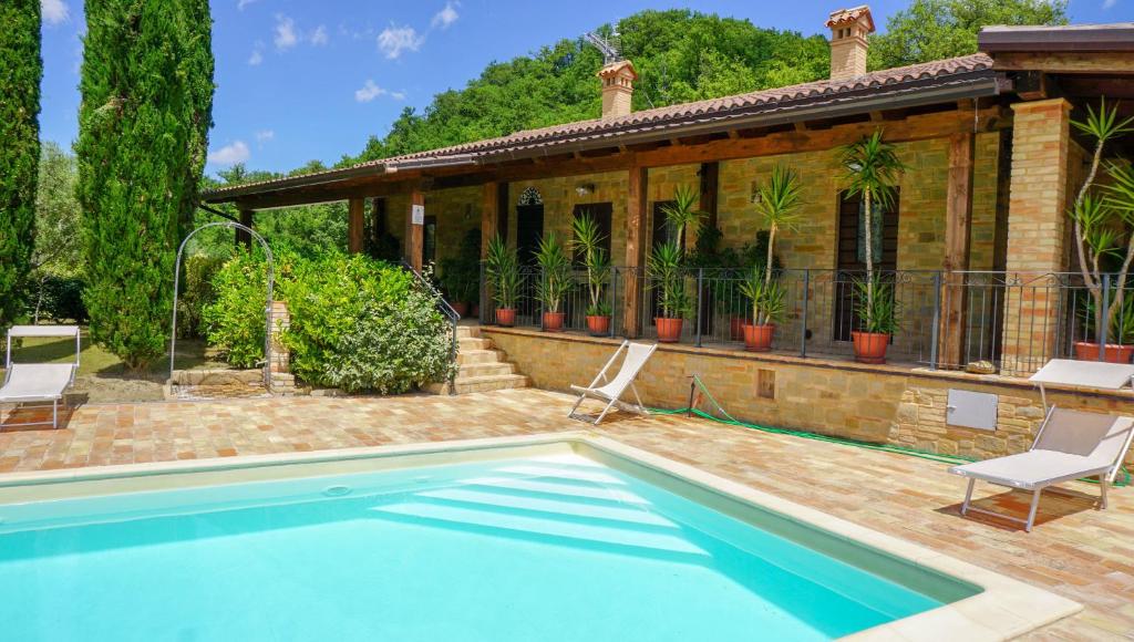 a swimming pool in front of a house at Agriturismo Pascucci in Tolentino