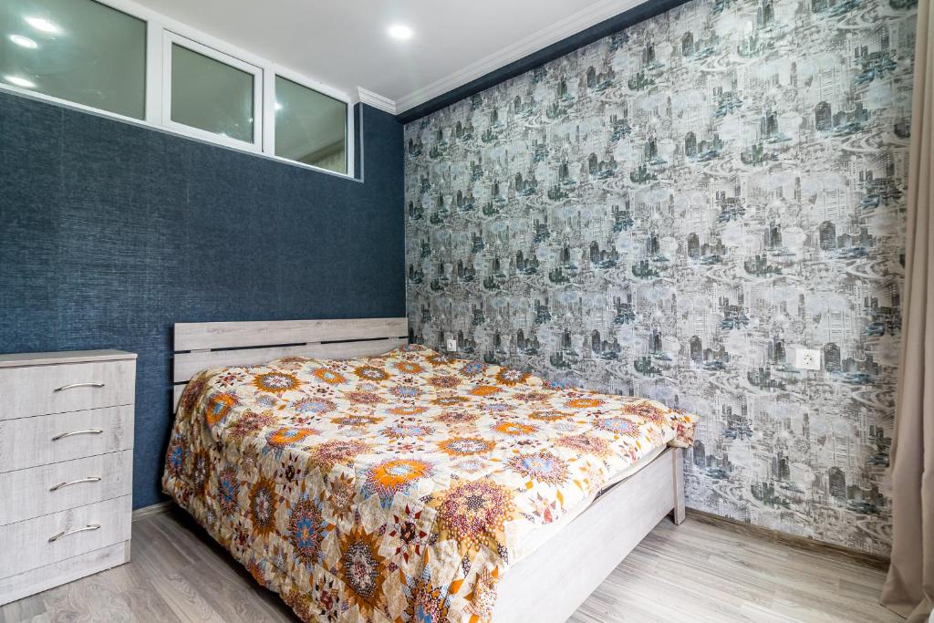 a bedroom with a bed and a wall at Borjomi cozy home in Borjomi