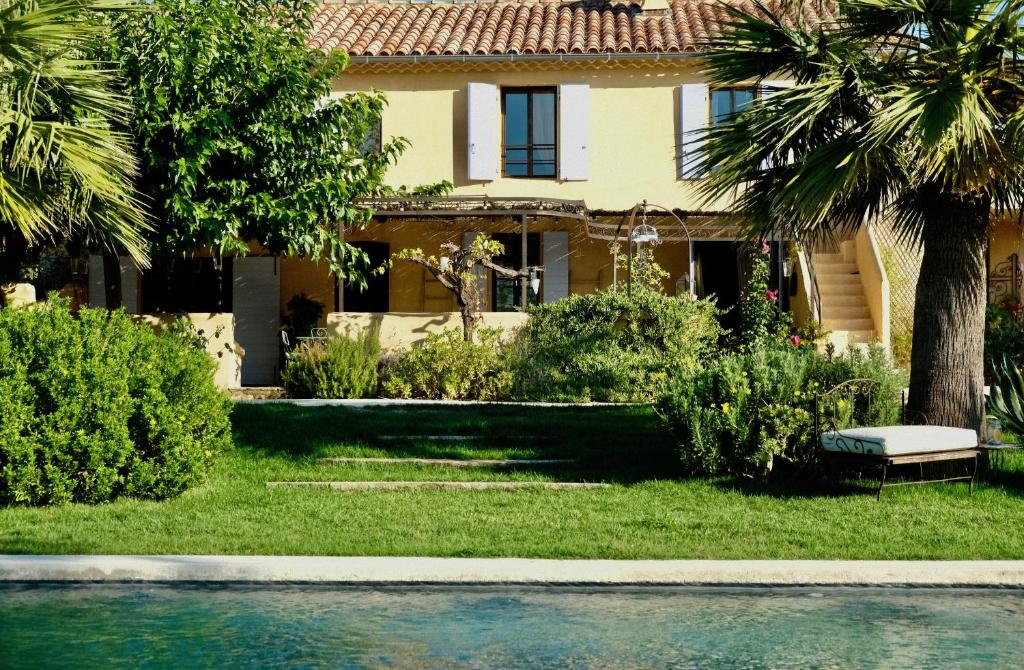 une maison avec une piscine et des palmiers dans l'établissement Clos BB, à Saint-Cyr-sur-Mer