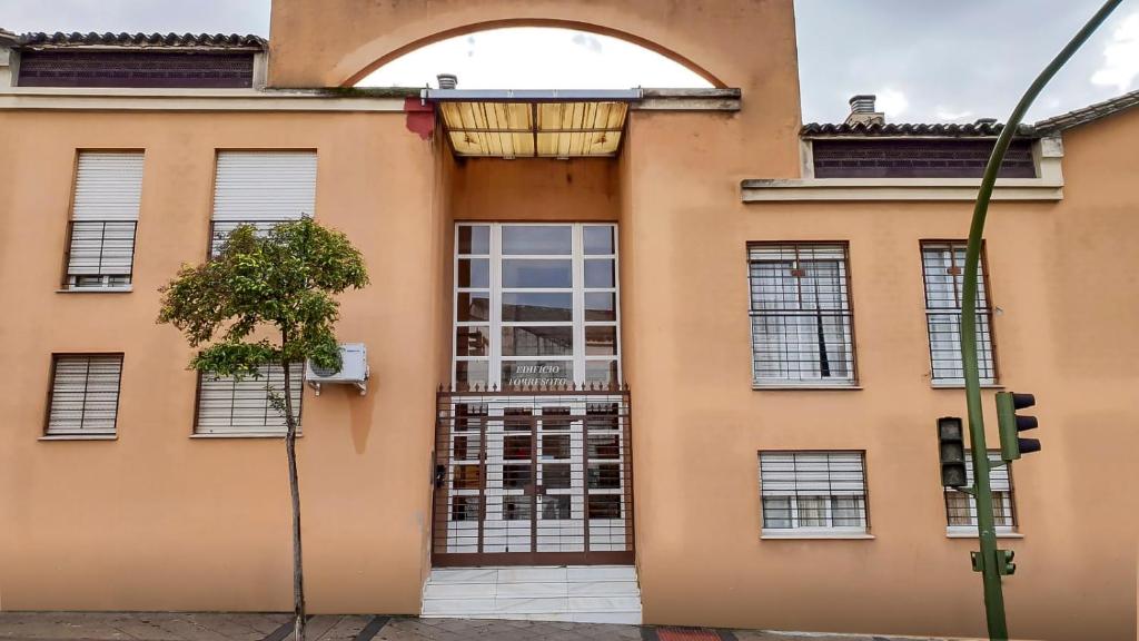 ヘレス・デ・ラ・フロンテーラにあるApartamento Patriの窓門付きのオレンジ色の建物