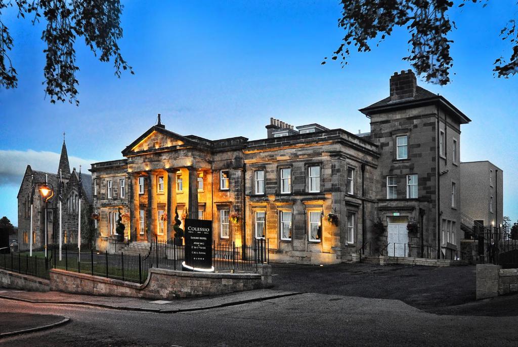 un viejo edificio con un cartel delante en Hotel Colessio, en Stirling