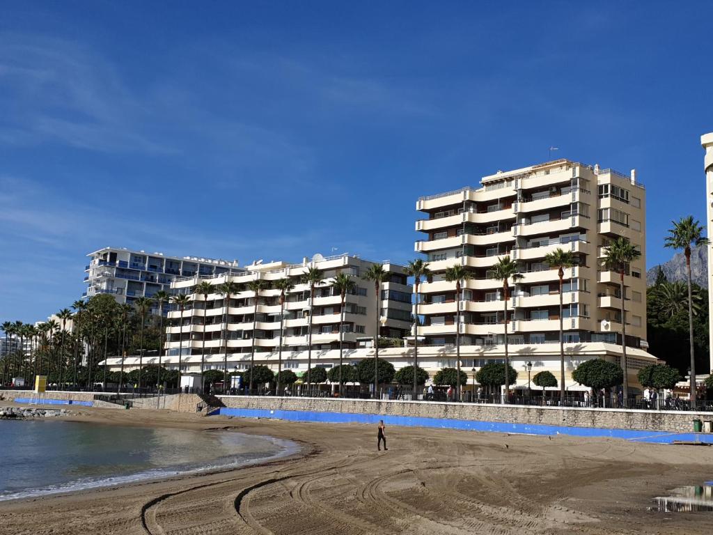 マルベーリャにあるAmazing Sea Views over Marbella Portの大きな建物の前に立つ者