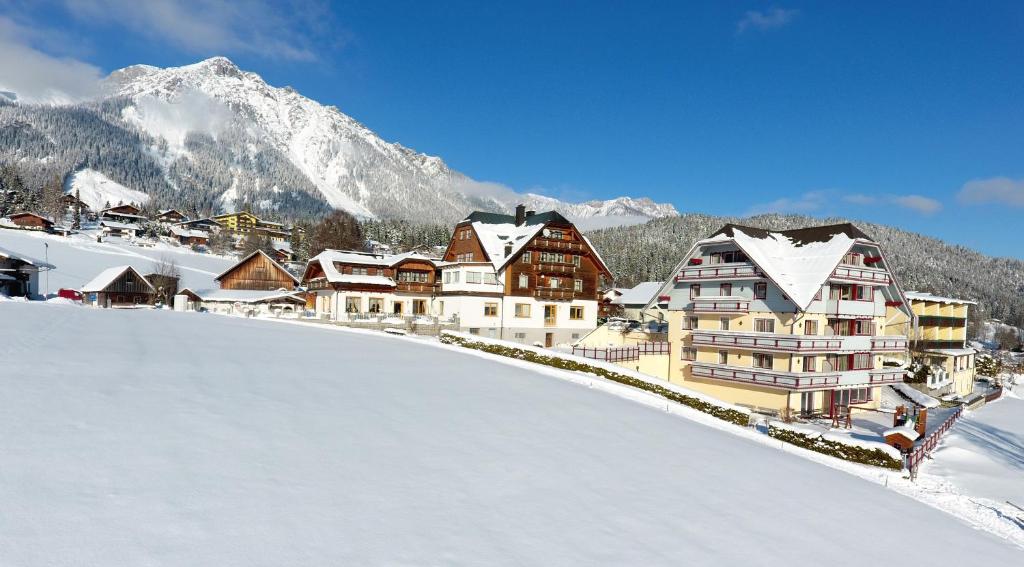 a resort in the mountains with snow on the ground at Hotel Neuwirt in Ramsau am Dachstein