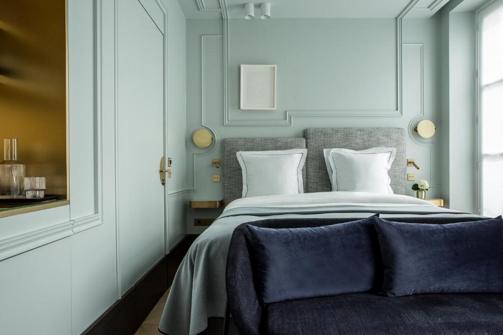 um quarto com uma cama grande e almofadas brancas em Maison Armance - Esprit de France em Paris