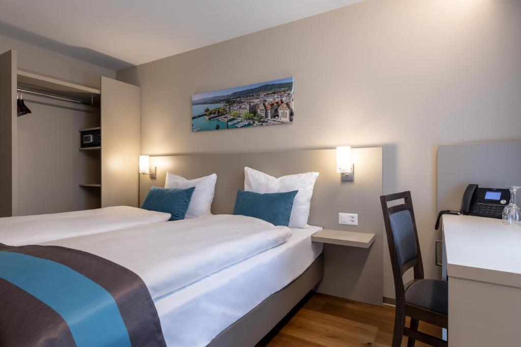 Una habitación de hotel con dos camas y un escritorio. en Trip Inn Zurich Hotel, en Zúrich