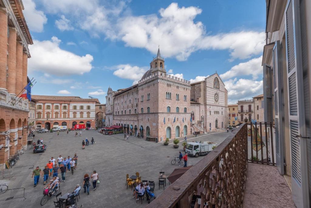 grupa ludzi spacerujących po ulicy miejskiej w obiekcie La Residenza in Piazza Grande w mieście Foligno