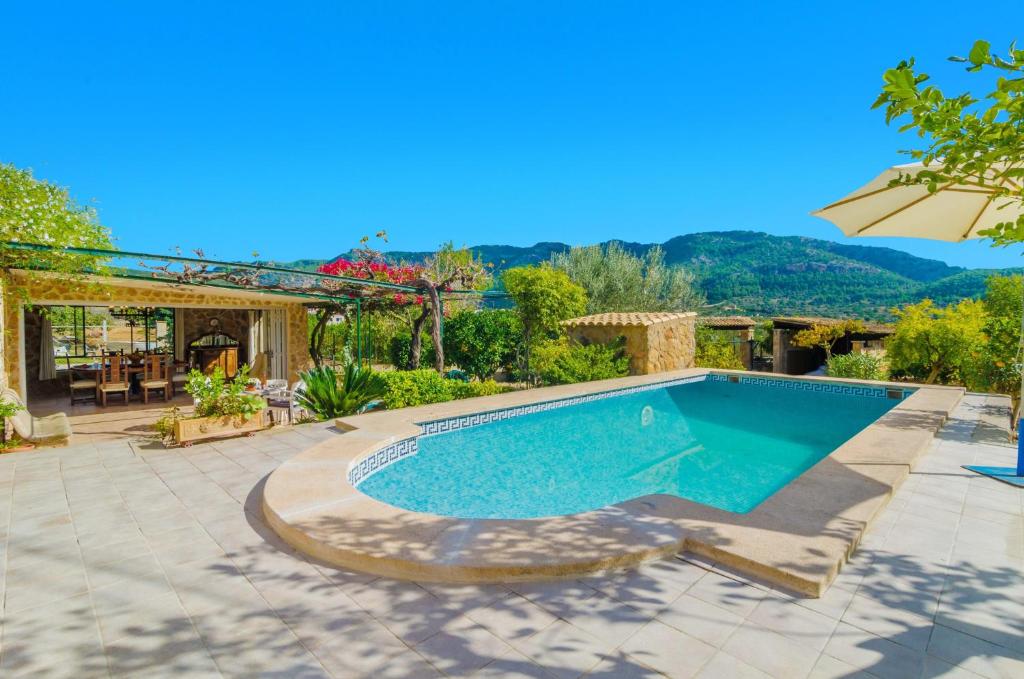 una piscina en un patio con sombrilla en Casa Margarita, en Andratx