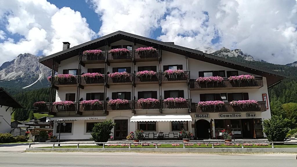 un hotel con flores en sus balcones en Hotel Comelico, en Padola