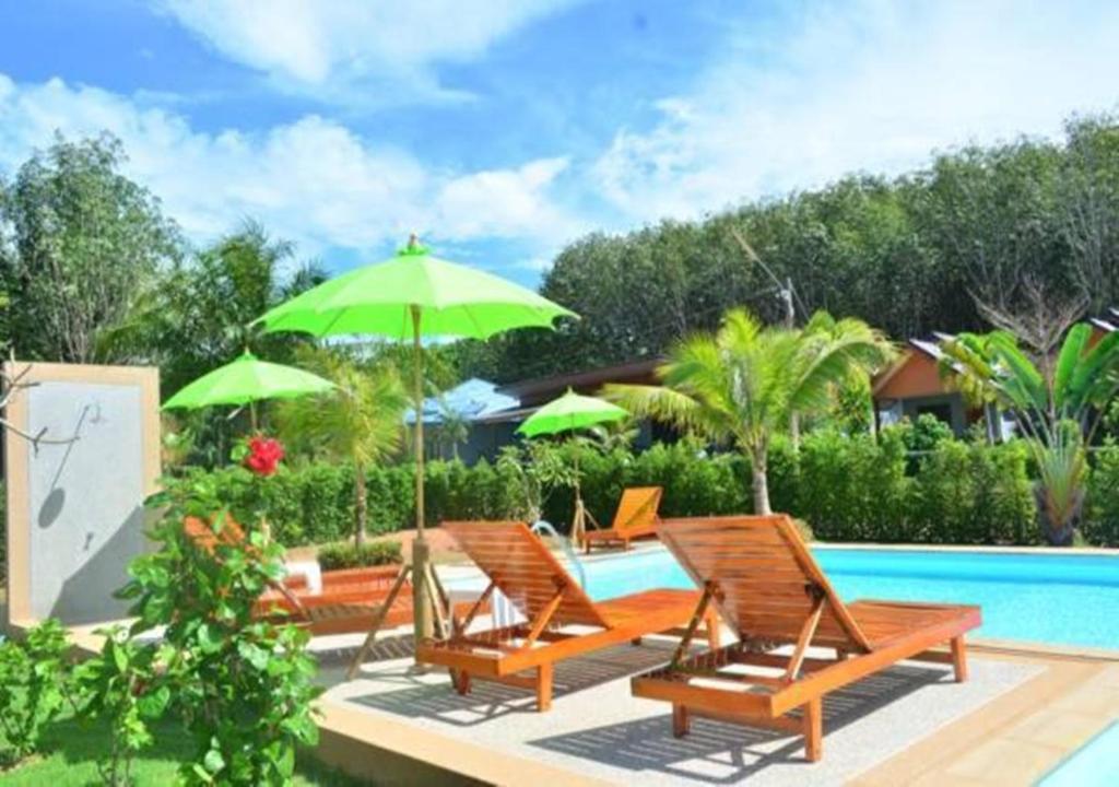 a group of chairs and umbrellas next to a swimming pool at Veranda Lanta Resort in Ko Lanta