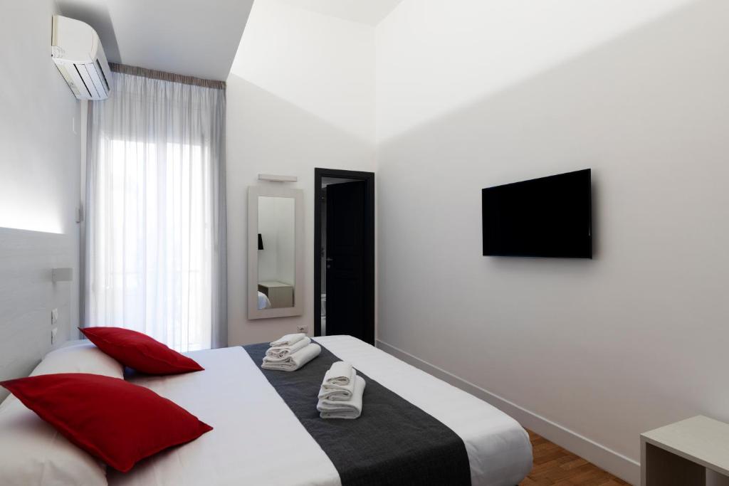 a bedroom with two beds with red pillows at Acate81 Lifestyle Apartment in Naples