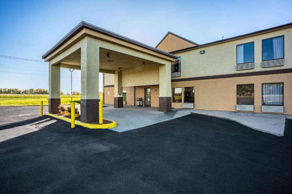 un parking vide devant un bâtiment dans l'établissement American inn and suites, à Galesburg