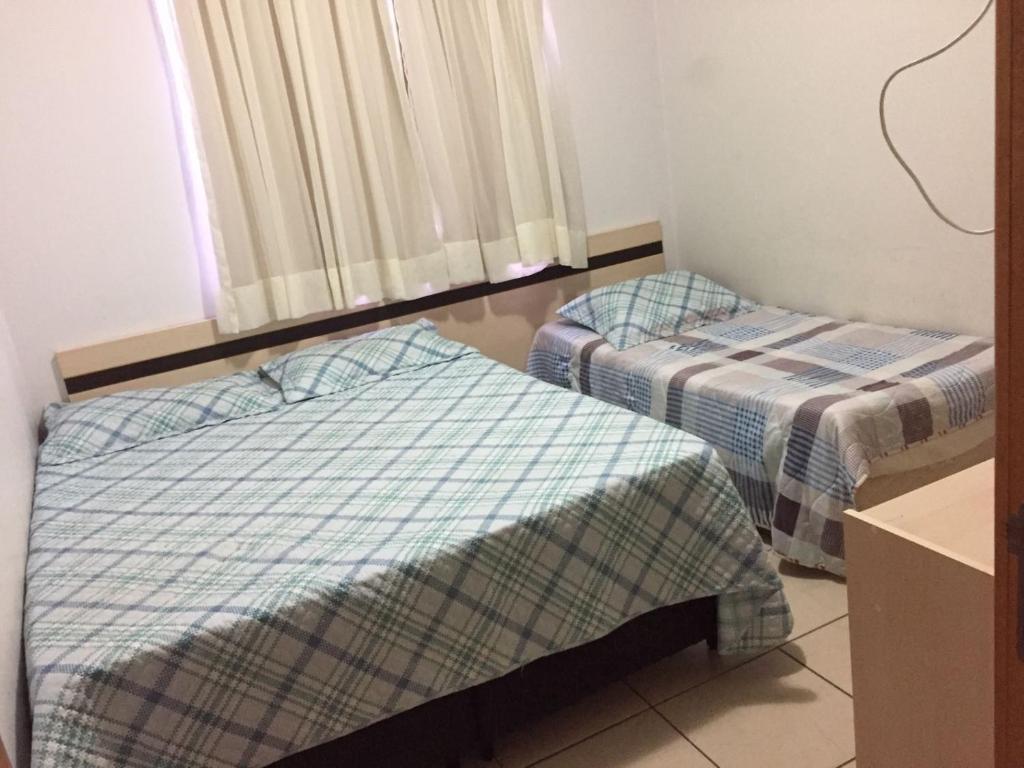 a room with two beds and a window at Aguas da Serra in Rio Quente