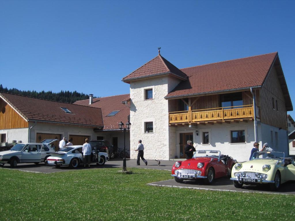eine Gruppe von Autos, die vor einem Haus geparkt sind in der Unterkunft La Tour du Coq Doré in Granges-Narboz