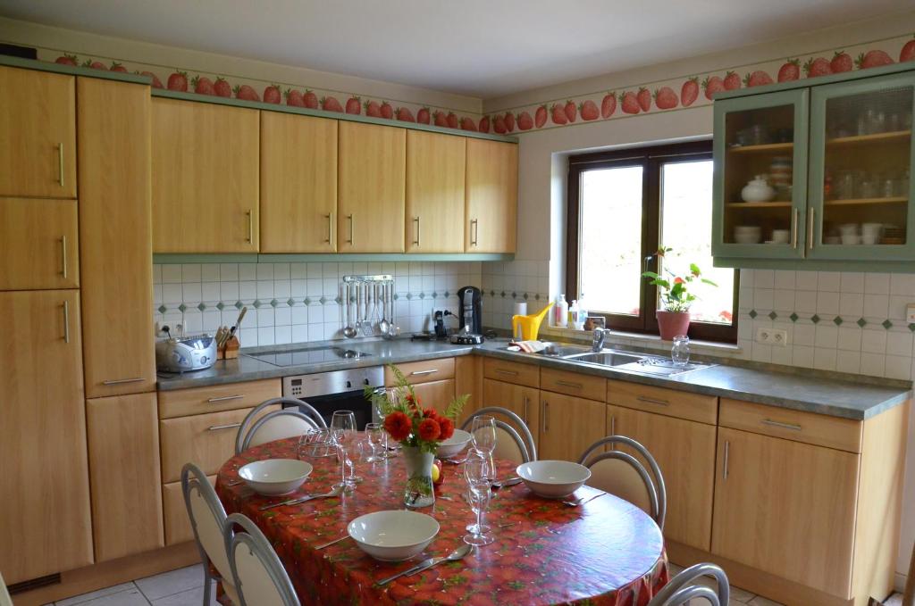 a kitchen with a table with chairs and a sink at Gîte A La Violette in Trois-Ponts
