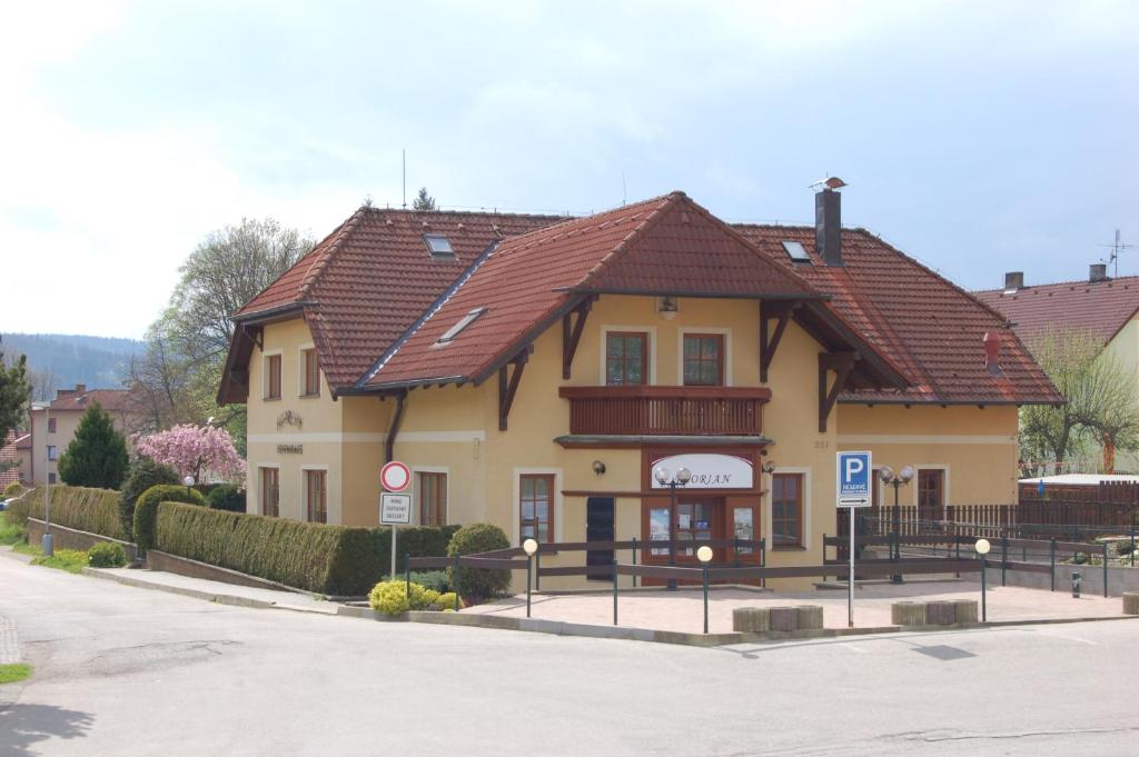 ein großes gelbes Gebäude mit braunem Dach in der Unterkunft Penzion Florian in Frymburk