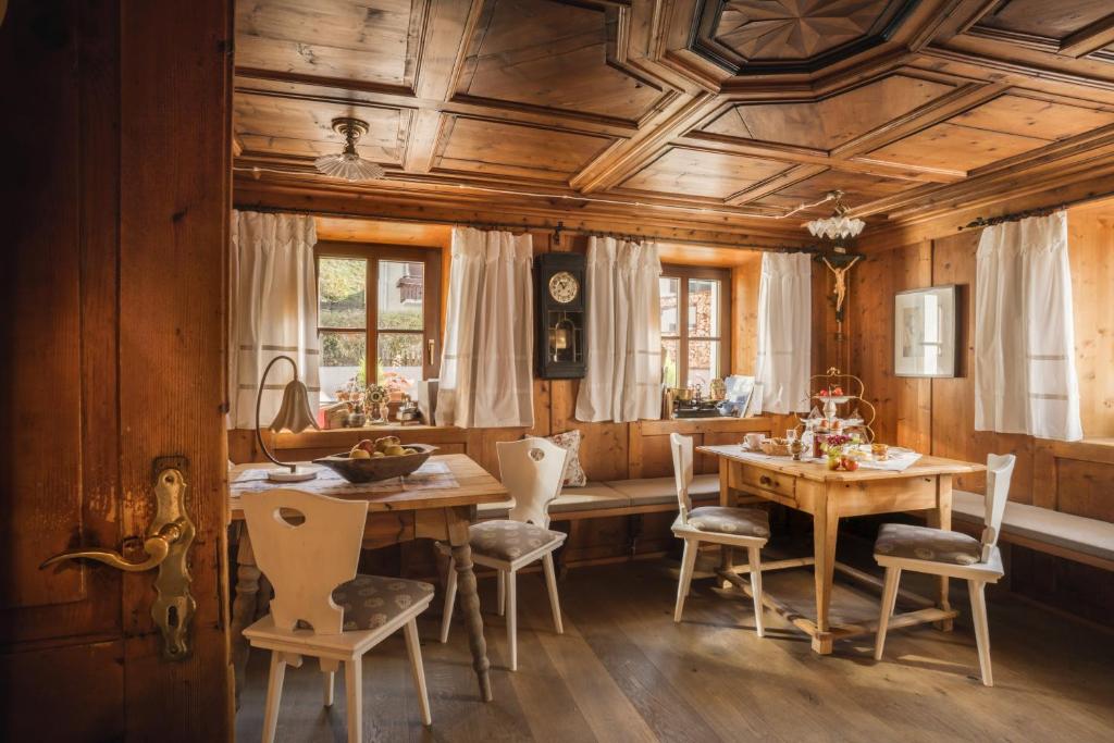 a dining room with wooden ceilings and a table and chairs at Gabis kleine Spezerey in Gries am Brenner