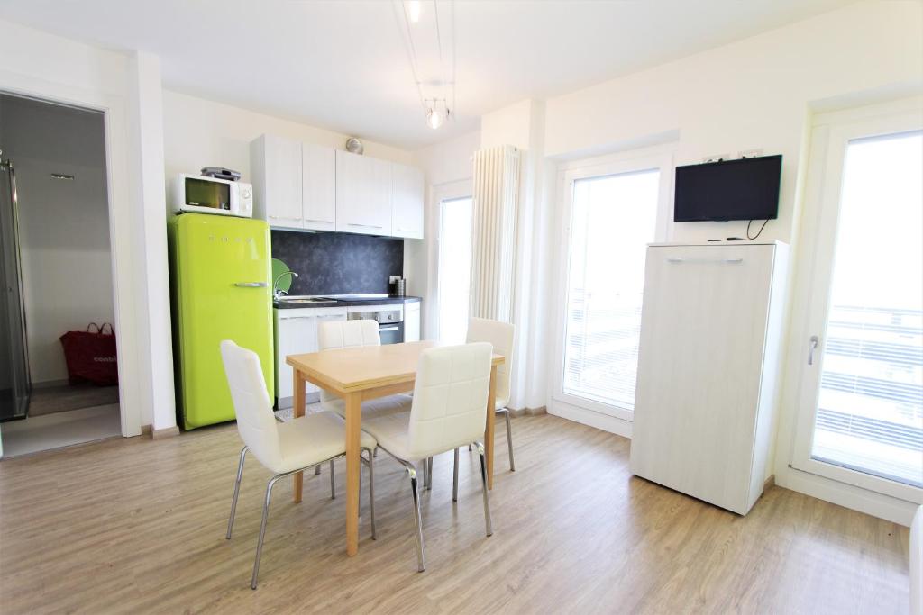 a kitchen and dining room with a table and chairs at Hostdomus - Green Tech Apartment in Sestriere