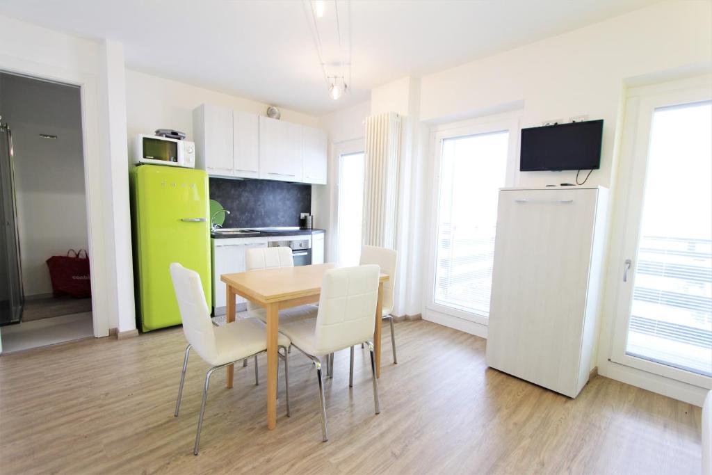 een keuken en eetkamer met een tafel en stoelen bij Hostdomus - Green Tech Apartment in Sestriere