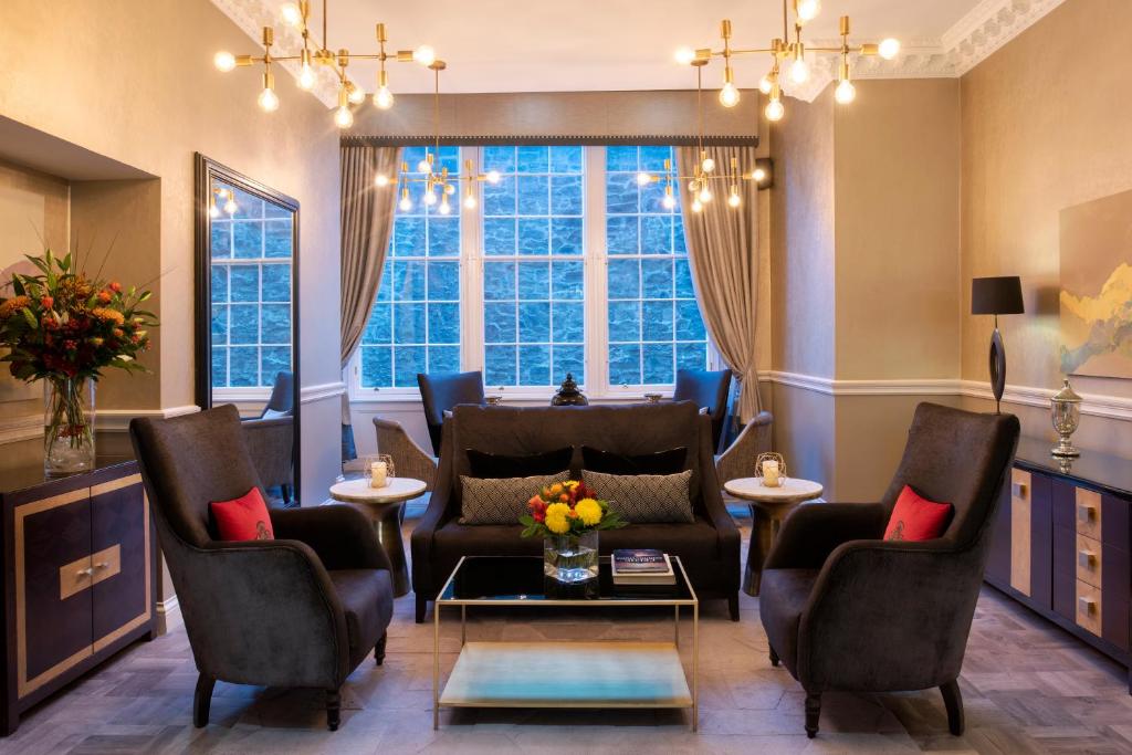 a living room with chairs and a couch and a window at Fraser Suites Edinburgh in Edinburgh